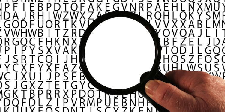 magnifying glass hovering over grid of letters