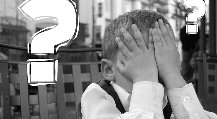 boy with hands over face and question mark
