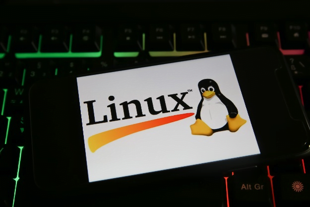 Linux logo on a piece of card in front of a keyboard.
